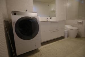 a washing machine in a bathroom with a toilet at ERUMAYA Resort in Motobu +20 photos