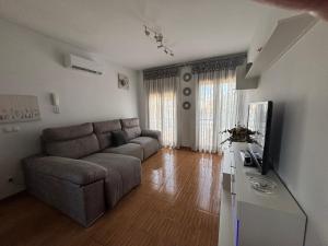 a living room with a couch and a television at Capricho in Burunchel