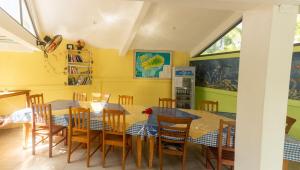 a dining room with a table and wooden chairs at Merlin Guest House in Rodrigues Island