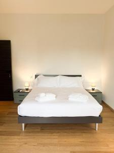a bedroom with a white bed with two night stands at Le Tre Lune Rooms in Matera
