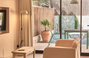 a living room with a patio with a table and chairs at L'Aixart Aiguablava Hotel in Begur