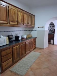 a kitchen with wooden cabinets and a microwave at Casa Galante in Furnas