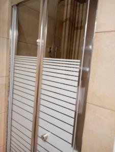 eine Duschtür aus Glas im Badezimmer in der Unterkunft Angelos Apartment in Vathy