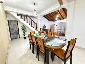 a dining room with a wooden table and chairs at Arora Villa in Digana