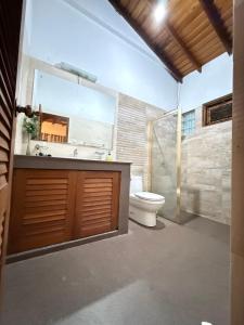 a bathroom with a toilet and a sink and a mirror at Arora Villa in Digana