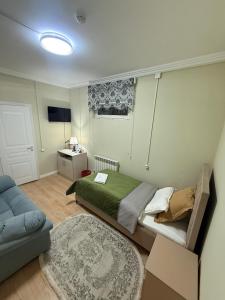 a bedroom with a bed and a couch at Duman House in Almaty