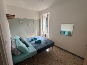a bedroom with a bed with blue pillows and a mirror at Lo Scorcio sul porto in Porto Santo Stefano