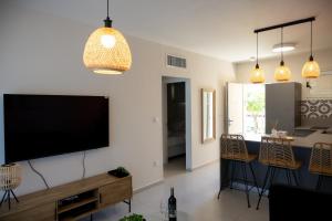 a living room with a flat screen tv on a wall at Liz suite in Caesarea