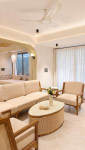 a living room with a couch and chairs and a table at The Elysian Morjim 150 Meters to Morjim Beach in Morjim