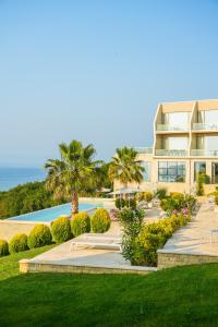 a view of a resort with palm trees and a building at PRIVE The Luxury Villa & Boutique Hotel, Cape of Rodon in Draç