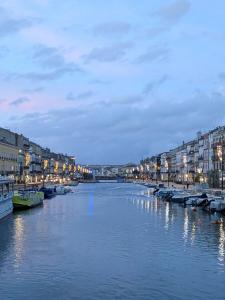 a river in a city with buildings and boats on it at Sète Centre ville T2 rénové in Sète