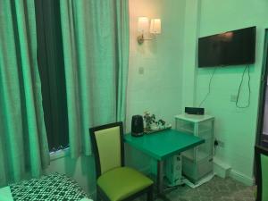 a room with a desk and a telephone and a bed at Ababeel Hotel in Birmingham