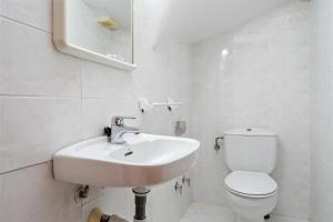 a white bathroom with a sink and a toilet at Hauzify I Casa Arboç in Platja d'Aro