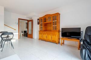 a living room with a television and a wooden cabinet at Hauzify I Casa Arboç in Platja d'Aro