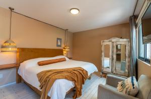 a bedroom with a large bed and a chair at Casa H in San Miguel de Allende +25 photos