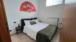 a bedroom with a bed with white sheets and a window at Faraboni Apartments in Novara