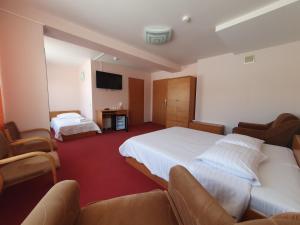 a hotel room with two beds and a tv at Hotel Madona in Madona
