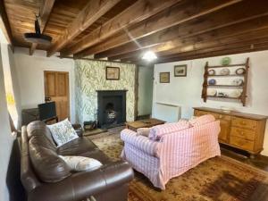 a living room with a couch and a fireplace at Cissy's Cottage in Hawes