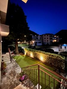 a balcony with a green lawn at night at El Jardin in Bellano