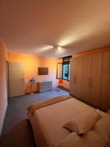 a bedroom with a large bed and a dresser at El Jardin in Bellano
