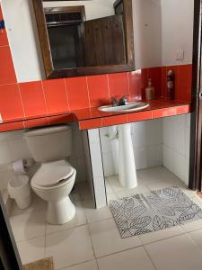 a bathroom with a toilet and a sink at Finca Cafetera Madrigal - Café Sortiz in Maravélez