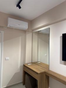 a room with a wooden table and a tv on a wall at Vila Llaman Luxury Rooms in Himare +19 photos