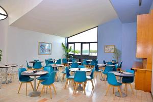 a dining room with tables and blue chairs at HA Hotel in Bracciano