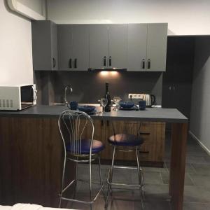 a kitchen with two bar stools and a counter at Lux na Druhetiv in Uzhhorod