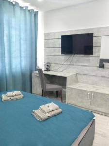 a room with a bed with a desk and a tv at Lux na Druhetiv in Uzhhorod