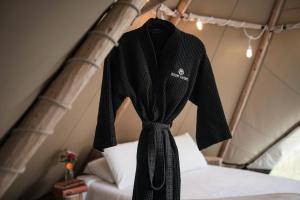 a robe hanging on a bed in a tent at Bodhi Farms in Bozeman +18 photos