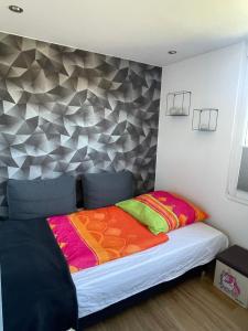 a bedroom with a bed with a geometric wall at Ferienwohnung Wiesenweg in Friedrichroda