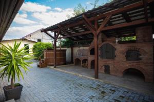an outdoor patio with a brick building with a wooden pergola at Vila Medana- Neamt in Humuleşti