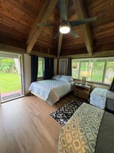 a bedroom with two beds and a ceiling fan at Kaena O Kekai in Hauula