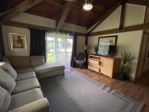 a living room with a couch and a tv at Kaena O Kekai in Hauula