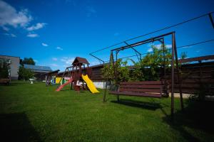 a park with a playground with a bench and a slide at Vila Medana- Neamt in Humuleşti