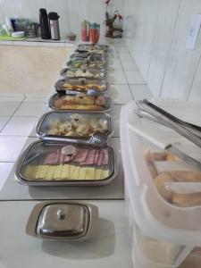 a long row of trays of food in a kitchen at Hotel R Soares 2 in Carutapera +14 photos