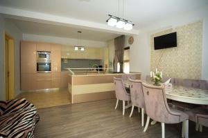 a kitchen and dining room with a table and chairs at Vila Medana- Neamt in Humuleşti