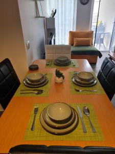 a dining room table with plates and utensils on it at Gjiri I Lalzit apartament in Draç +17 photos