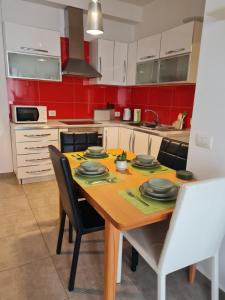 a kitchen with a wooden table with black chairs at Gjiri I Lalzit apartament in Draç