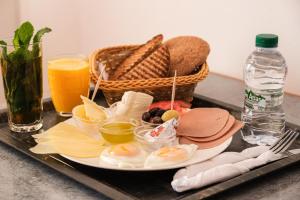 a tray with a plate of eggs and toast and a basket of bread at Hotel Fnidaq in Fnidek +28 photos
