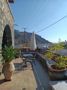 a patio with a table and chairs and an umbrella at Kalo Nero Apartments in Makry Gialos