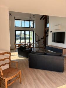 a living room with a couch and a tv and a chair at La Claverie in Cholet