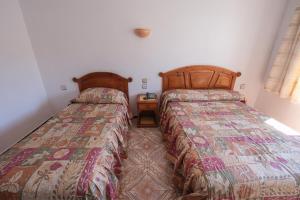 a bedroom with two beds and a night stand at Hotel Fnidaq in Fnidek