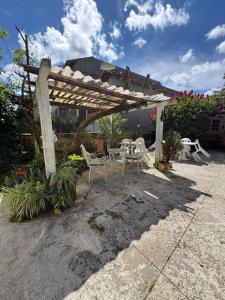 a patio with a table and chairs under a pergola at Casa na "Villa Grega" pertinho do Parque Nacional, Feirinha do Alto e Granja Comary in Teresópolis
