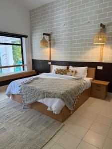 a bedroom with a bed and a brick wall at Sukoon in Nainital