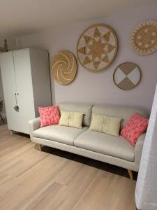 a living room with a couch and some pictures on the wall at Duijnparadijs appartement 2 in Schoorl