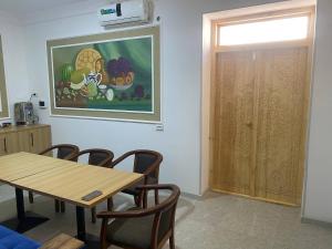 a dining room with a table and chairs and a painting on the wall at Gavhar Boutique Hotel in Khiva