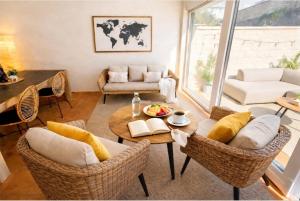 a living room with a table and wicker chairs at VILLA PANGEA Habitaciones Boutique - Camino del Norte - Castro Urdiales in Castro-Urdiales