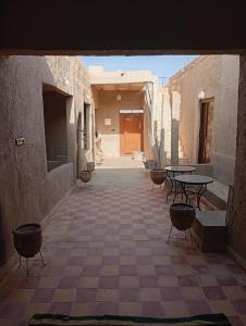 an empty courtyard with tables and chairs in a building at Guesthousefamillytakojt in Merzouga