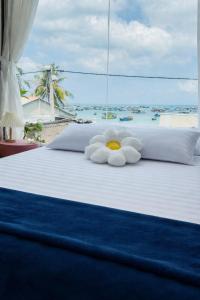 a white bed with a stuffed animal on it at Home Sake Hòn Sơn in Lai Sơn